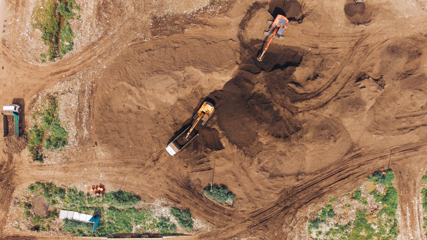 Aerial view of construction site with excavators and trucks working on brown earth in Chennai India. Aerial view of construction site with excavators and trucks working on brown earth in Chennai India.