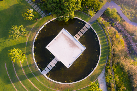 Aerial view of a modern square pavilion centered in a circular pond with stone walkways and lush green lawns in Cape Town Western Cape South Africa. Aerial view of a modern square pavilion centered in a circular pond with stone walkways and lush green lawns in Cape Town Western Cape South Africa.