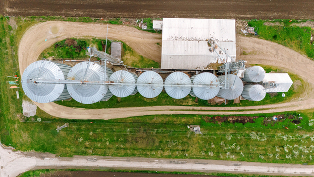 Aerial view of a symmetrical array of grain silos and agricultural buildings nestled amid fields with contrasting textures Sremska Mitrovica Vojvodina Serbia. Aerial view of a symmetrical array of grain silos and agricultural buildings nestled amid fields with contrasting textures Sremska Mitrovica Vojvodina Serbia.