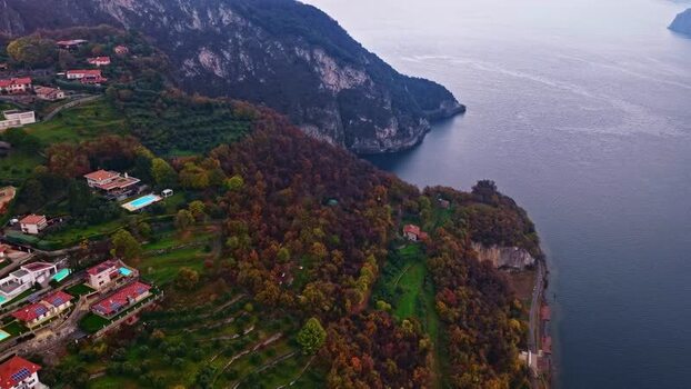 Aerial view of hillside houses and lake in Italy.