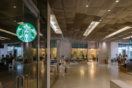 Giza Egypt 16 May 2026 View of the Grand Egyptian Museum interior featuring a Starbucks coffee shop storefront with people walking through the modern hall and polished floors.