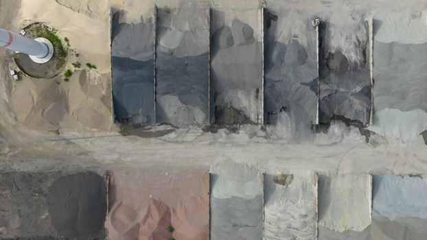 Aerial view of Feluy de Parc Industriel showing various piles of industrial gravel and aggregate stored in concrete bays in Seneffe Region wallonne Belgium.