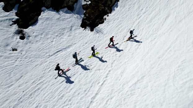 Aerial view of a group of ski tourers climbing a steep snowy slope near Pointe Ronde and rocky outcrops in Trient Valais Switzerland.