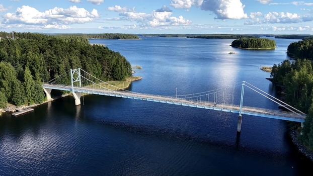 Aerial view of Potkusalmen silta Bridge spanning the calm blue waters of the lake surrounded by dense pine forests in Savonlinna Etela Savo Finland. Aerial view of Potkusalmen silta Bridge spanning the calm blue waters of the lake surrounded by dense pine forests in Savonlinna Etela Savo Finland.
