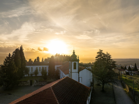 Vila Pouca da Beira Portugal 31 December 2023 Aerial view of Lam Hotel Convento do Desagravo with its historic bell tower and red tiled roofs under a golden sunset sky. Vila Pouca da Beira Portugal 31 December 2023 Aerial view of Lam Hotel Convento do Desagravo with its historic bell tower and red tiled roofs under a golden sunset sky.