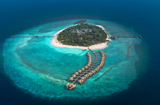 Aerial view of a luxury tropical resort island with overwater bungalows white sand beaches and turquoise coral reefs in Hoarafushi Haa Alif Atoll Maldives. Aerial view of a luxury tropical resort island with overwater bungalows white sand beaches and turquoise coral reefs in Hoarafushi Haa Alif Atoll Maldives.