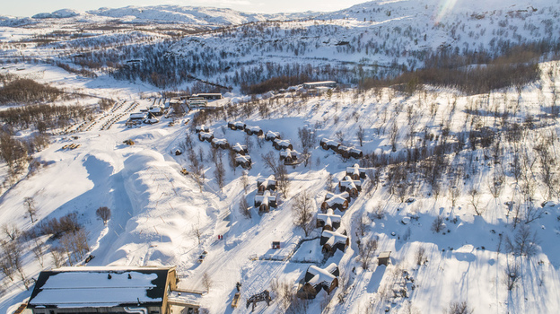 Aerial view of the Snowhotel cabins nestled in a snowy arctic landscape with bright sunlight and long shadows in Kirkenes Finnmark Norway. Aerial view of the Snowhotel cabins nestled in a snowy arctic landscape with bright sunlight and long shadows in Kirkenes Finnmark Norway.