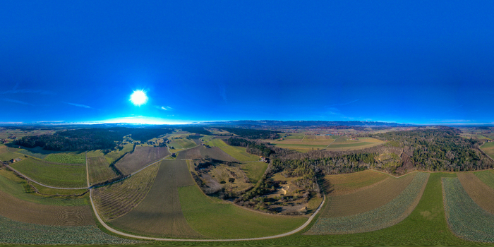 Aerial view of the Seeland District featuring vast agricultural fields and dense forests under a bright sun in Grossaffoltern Bern Switzerland. Aerial view of the Seeland District featuring vast agricultural fields and dense forests under a bright sun in Grossaffoltern Bern Switzerland.