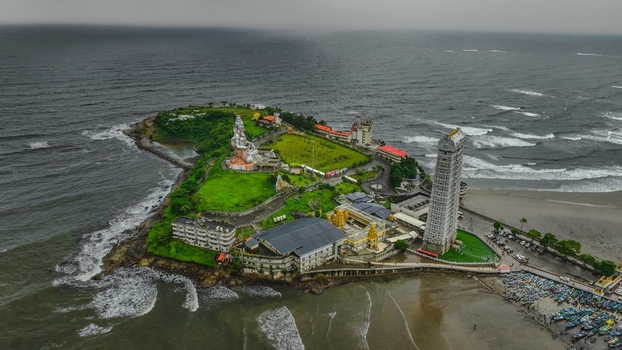 Aerial view of the Murudeshwar Temple complex featuring the massive Shiva statue and the towering Raja Gopura surrounded by the Arabian Sea in Murdeshwar Karnataka India.