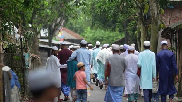 View of Muslim men walking along a village road in Bogura Bangladesh. View of Muslim men walking along a village road in Bogura Bangladesh.