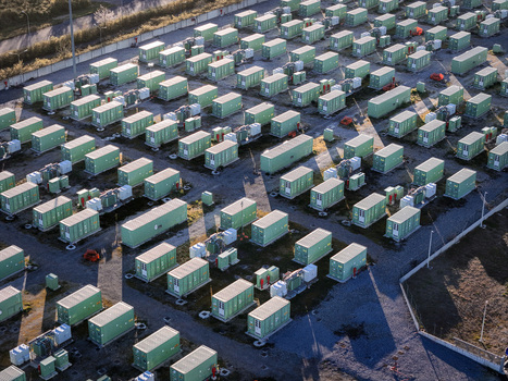 Trino Italy 30 March 2026 Aerial view of a grid of neatly arranged green containers casting long shadows across the paved landscape a testament to organized industry. Trino Italy 30 March 2026 Aerial view of a grid of neatly arranged green containers casting long shadows across the paved landscape a testament to organized industry.