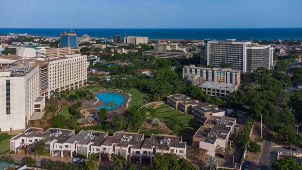 Accra Ghana 26 May 2023 Aerial view of Movenpick Ambassador Hotel Accra featuring its large swimming pool lush gardens and surrounding urban landscape under a clear blue sky. Accra Ghana 26 May 2023 Aerial view of Movenpick Ambassador Hotel Accra featuring its large swimming pool lush gardens and surrounding urban landscape under a clear blue sky.