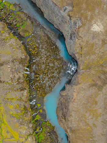 Aerial view of Sigoldugljufur canyon with its vibrant blue river flowing through rocky moss covered cliffs in Rangarthing ytra Iceland. Aerial view of Sigoldugljufur canyon with its vibrant blue river flowing through rocky moss covered cliffs in Rangarthing ytra Iceland.