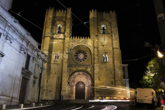 View of the historic Lisbon Cathedral at night with its illuminated stone facade twin towers and rose window in Lisbon Lisbon Portugal. View of the historic Lisbon Cathedral at night with its illuminated stone facade twin towers and rose window in Lisbon Lisbon Portugal.
