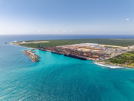 Aerial view of DP World Dominicana port facility with container ships cranes and shipping containers along the turquoise Caribbean coast in Boca Chica Santo Domingo Dominican Republic. Aerial view of DP World Dominicana port facility with container ships cranes and shipping containers along the turquoise Caribbean coast in Boca Chica Santo Domingo Dominican Republic.