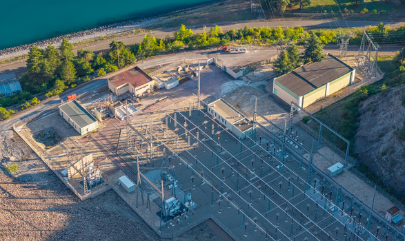 Aerial view of an electrical substation with utility buildings and power infrastructure located next to a mountain reservoir in Rousset Serre Poncon Provence Alpes Cote d Azur France. Aerial view of an electrical substation with utility buildings and power infrastructure located next to a mountain reservoir in Rousset Serre Poncon Provence Alpes Cote d Azur France.