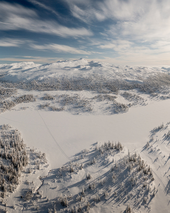 Aerial view of Gaustablikk Fjellresort surrounded by snow covered mountains frozen lakes and dense pine forests under a bright winter sky in Rjukan Telemark Norway. Aerial view of Gaustablikk Fjellresort surrounded by snow covered mountains frozen lakes and dense pine forests under a bright winter sky in Rjukan Telemark Norway.