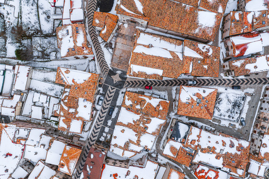 Aerial view of the historic town with snow covered terracotta rooftops and narrow streets in winter in Pescocostanzo Abruzzo Italy.