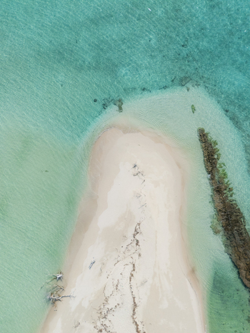 Aerial view of a glowing white sandbank against the vibrant turquoise sea and dark coral Thuraakunu Thiladhunmathee Uthuruburi Maldives. Aerial view of a glowing white sandbank against the vibrant turquoise sea and dark coral Thuraakunu Thiladhunmathee Uthuruburi Maldives.