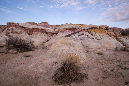 View of Paint Mines Interpretive Park featuring colorful geological formations and layered clay under a soft blue sky Calhan Colorado United States.