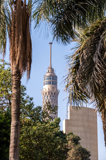 Aerial view of the iconic Cairo Tower piercing the skyline amidst lush greenery and framed by swaying palms Cairo Egypt. Aerial view of the iconic Cairo Tower piercing the skyline amidst lush greenery and framed by swaying palms Cairo Egypt.