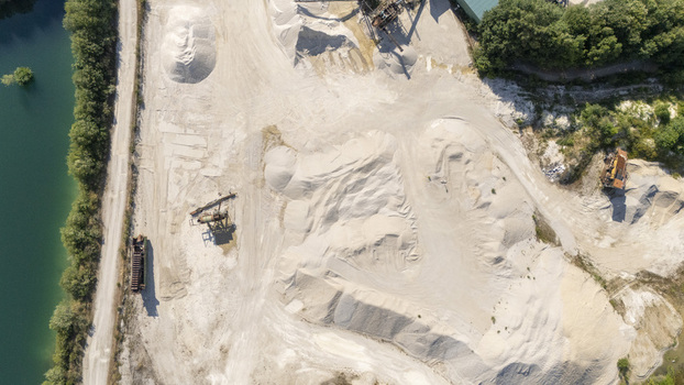 Aerial view of Extraccion de aridos Lima S.L quarry with piles of sand gravel heavy machinery and a water reservoir in Vilarino das Poldras Ourense Spain. Aerial view of Extraccion de aridos Lima S.L quarry with piles of sand gravel heavy machinery and a water reservoir in Vilarino das Poldras Ourense Spain.
