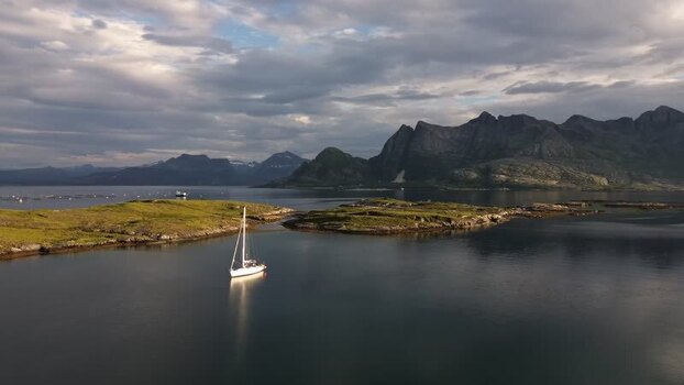 Aerial view of a sailboat in the calm waters of Senja Norway.