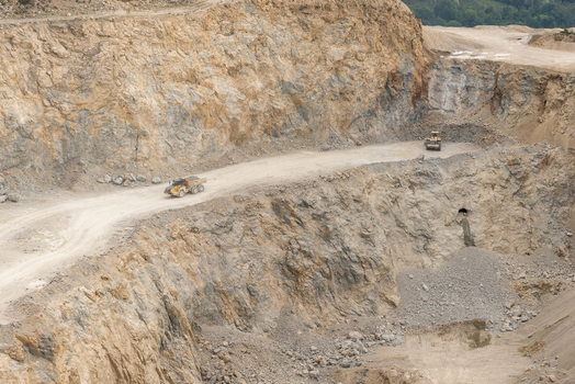 View of a quarry in the Apuseni Mountains with a dump truck and bulldozer operating on the rocky excavation site in Horea Alba County Romania. View of a quarry in the Apuseni Mountains with a dump truck and bulldozer operating on the rocky excavation site in Horea Alba County Romania.