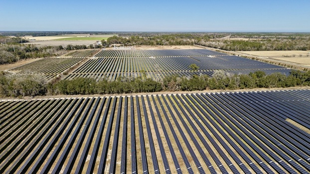 Aerial view of rows upon rows of solar panels stretch across the landscape glinting under the sunlight Elkton Florida United States. Aerial view of rows upon rows of solar panels stretch across the landscape glinting under the sunlight Elkton Florida United States.