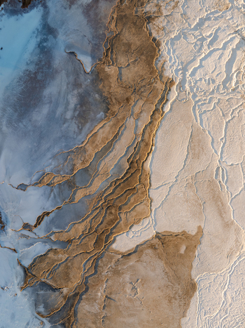 Aerial view of Reykjanes geothermal landscape featuring intricate mineral deposits textured terrain and geothermal pools in Grindavikurbaer Iceland. Aerial view of Reykjanes geothermal landscape featuring intricate mineral deposits textured terrain and geothermal pools in Grindavikurbaer Iceland.