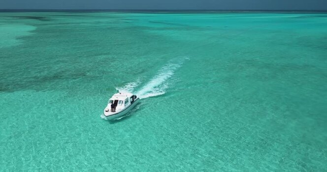 Aerial view of a white boat on turquoise water in Maldives. Aerial view of a white boat on turquoise water in Maldives.