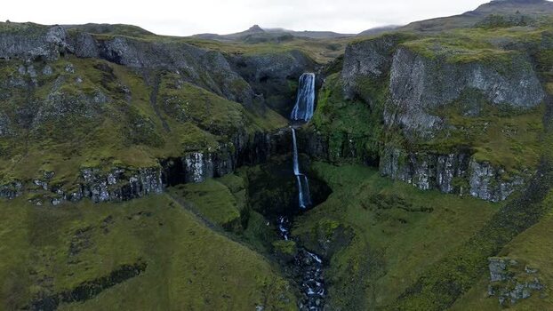 Aerial view of Bugsfoss waterfall cascading down cliffs Iceland.
