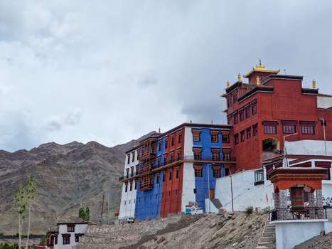 View of Matho Gompa a Tibetan Buddhist monastery with vibrant red white and blue walls set against a backdrop of arid mountains in Matho Ladakh India.
