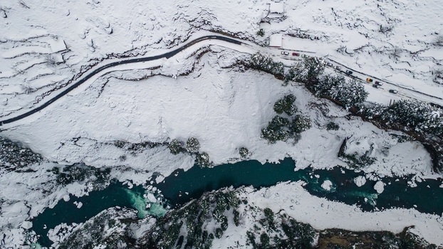 Aerial view of the vibrant turquoise river snaking through a snow laden landscape contrasting sharply with the dark winding road above Sharda Azad Kashmir Pakistan. Aerial view of the vibrant turquoise river snaking through a snow laden landscape contrasting sharply with the dark winding road above Sharda Azad Kashmir Pakistan.
