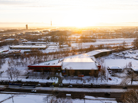 Riga Latvia 10 January 2025 Aerial view of Pepsi Centrs surrounded by snow covered grounds bare trees and urban infrastructure during a bright winter sunrise. Riga Latvia 10 January 2025 Aerial view of Pepsi Centrs surrounded by snow covered grounds bare trees and urban infrastructure during a bright winter sunrise.