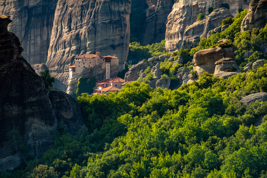 Aerial view of the Meteora monastery perched on high sandstone rock formations surrounded by lush green forest in Trikala Greece. Aerial view of the Meteora monastery perched on high sandstone rock formations surrounded by lush green forest in Trikala Greece.