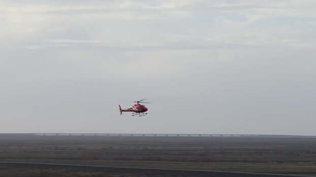 Aerial view of a red helicopter flying over the landscape Iceland. Aerial view of a red helicopter flying over the landscape Iceland.