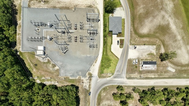 Aerial view of the Georgia Pacific Palatka Operations electrical substation featuring industrial equipment gravel grounds and adjacent forest in Palatka Florida United States.