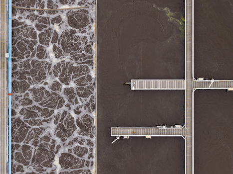 Aerial view of the Klarwerk Ruhleben sewage treatment plant featuring aeration tanks with bubbling water and industrial metal walkways in Berlin Berlin Germany.