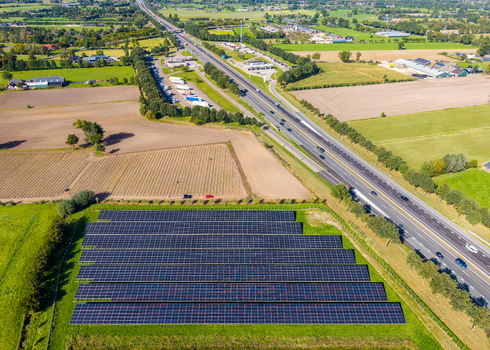 Aerial view of Solar Park with rows of photovoltaic panels situated next to a30 highway and agricultural fields in Ede Gelderland Netherlands. Aerial view of Solar Park with rows of photovoltaic panels situated next to a30 highway and agricultural fields in Ede Gelderland Netherlands.