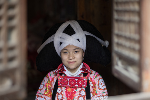 Gaoxing China 30 April 2026 View of a young woman wearing the traditional Long Horn Miao headdress and colorful embroidered clothing in a village. Gaoxing China 30 April 2026 View of a young woman wearing the traditional Long Horn Miao headdress and colorful embroidered clothing in a village.
