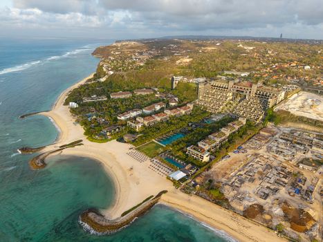 Aerial view of The Apurva Kempinski Bali resort featuring terraced architecture swimming pools and sandy beaches along the coastline in Kecamatan Kuta Selatan Bali Indonesia. Aerial view of The Apurva Kempinski Bali resort featuring terraced architecture swimming pools and sandy beaches along the coastline in Kecamatan Kuta Selatan Bali Indonesia.