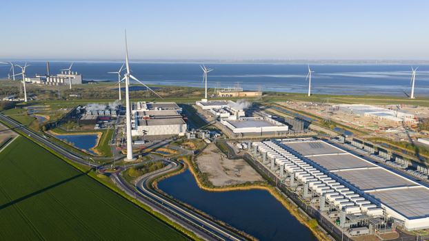 Aerial view of the Google Data Center and wind turbines surrounded by green fields and coastal waters in Eemshaven Groningen Netherlands. Aerial view of the Google Data Center and wind turbines surrounded by green fields and coastal waters in Eemshaven Groningen Netherlands.