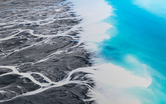 Aerial view of the braided river contrasting sharply with the turquoise waters of Lake Tekapo Lake Tekapo Canterbury Region New Zealand. Aerial view of the braided river contrasting sharply with the turquoise waters of Lake Tekapo Lake Tekapo Canterbury Region New Zealand.