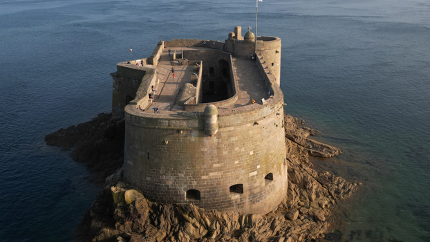 Aerial view of the imposing Ch&acirc;teau du Taureau a stone fortress rising from the dark swirling sea its weathered walls telling tales of centuries past Plouezoc h Bretagne France.