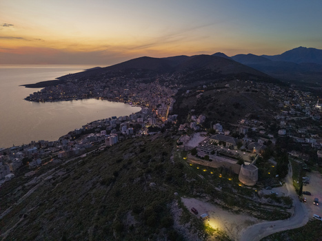 Aerial view of Lekuresi Castle overlooking the coastal city of Saranda and the bay at sunset in Saranda Vlore County Albania. Aerial view of Lekuresi Castle overlooking the coastal city of Saranda and the bay at sunset in Saranda Vlore County Albania.