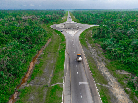 Aerial view of Bonny Island featuring a modern roundabout and asphalt road cutting through dense tropical forest in Bonny Town Rivers Nigeria. Aerial view of Bonny Island featuring a modern roundabout and asphalt road cutting through dense tropical forest in Bonny Town Rivers Nigeria.