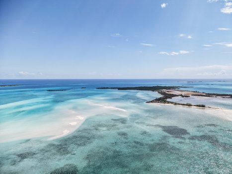 Aerial view of the Man O War Cay Sandbar surrounded by turquoise waters and tropical islands in Rolletown Exuma The Bahamas. Aerial view of the Man O War Cay Sandbar surrounded by turquoise waters and tropical islands in Rolletown Exuma The Bahamas.