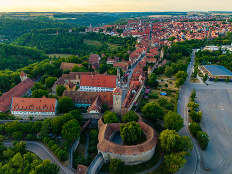 Aerial view of the historic town of Rothenburg ob der Tauber with its medieval walls red tiled rooftops and lush surrounding greenery in Rothenburg ob der Tauber Bavaria Germany. Aerial view of the historic town of Rothenburg ob der Tauber with its medieval walls red tiled rooftops and lush surrounding greenery in Rothenburg ob der Tauber Bavaria Germany.