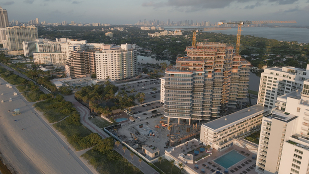Aerial view of a high rise construction site with cranes surrounded by hotels and residential buildings along the coastline in Miami Beach Florida United States. Aerial view of a high rise construction site with cranes surrounded by hotels and residential buildings along the coastline in Miami Beach Florida United States.